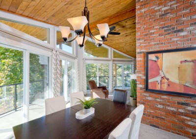 Dining table seating eight beside a wall of windows at MacKenzie House, Peachland BC