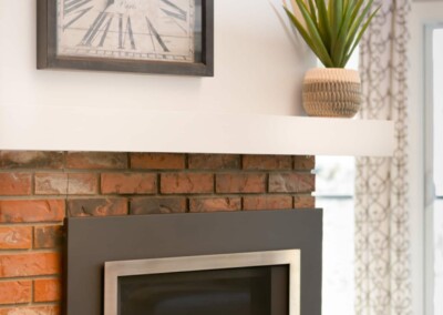 Brick fireplace with mantel in the living room at MacKenzie House, Peachland BC