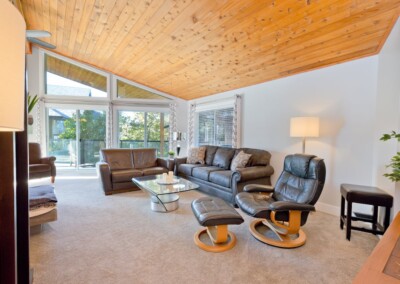 Open-plan living room with vaulted cedar ceiling and lake-facing windows, MacKenzie House Peachland