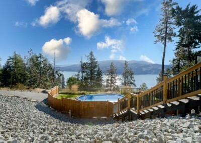 Pool deck surrounded by pines with lake views at MacKenzie House, Peachland BC