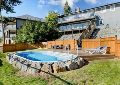 Pool with sun loungers in the fenced backyard at MacKenzie House, Peachland BC